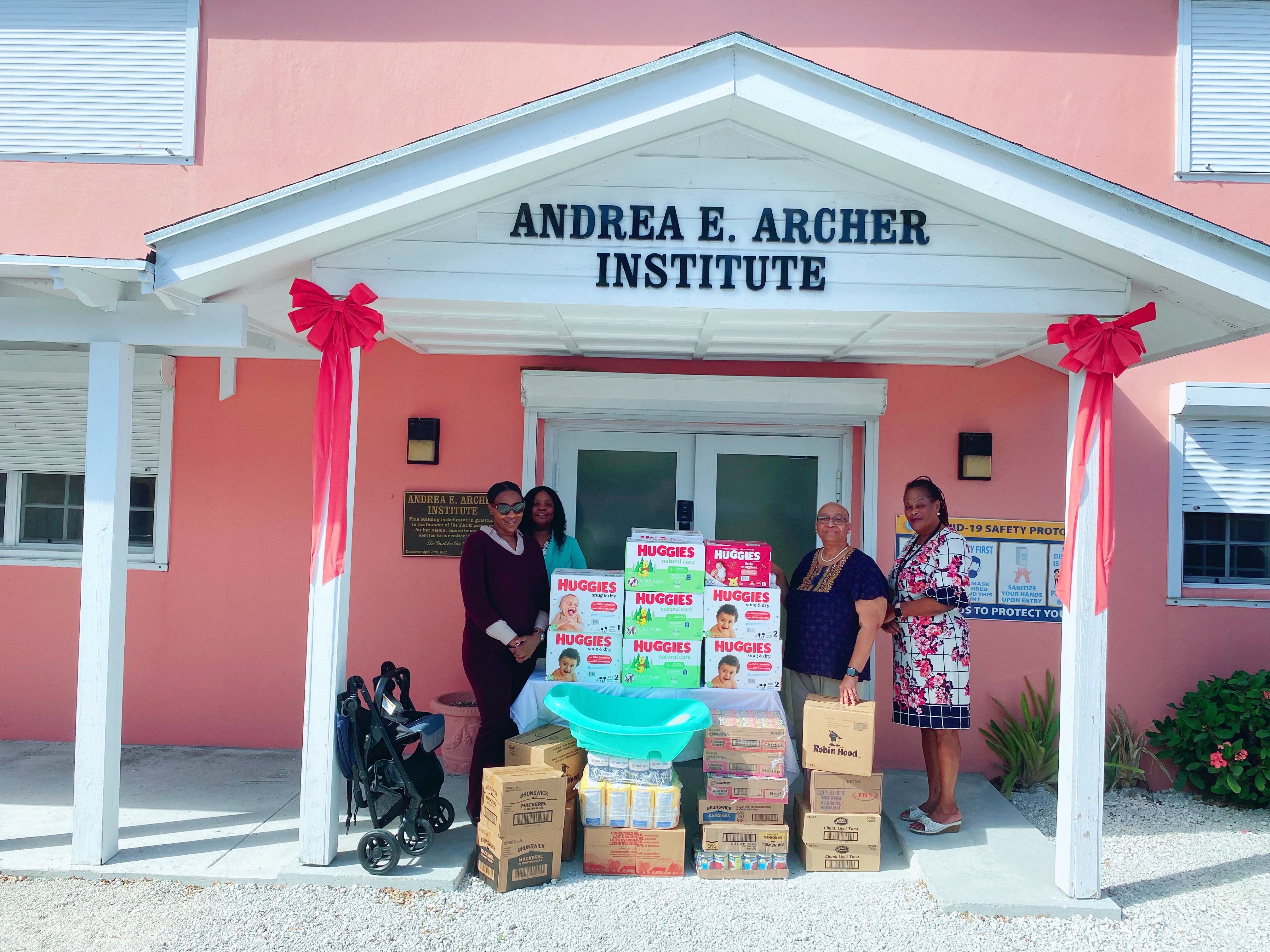 People standing in front of a building with boxes of donated items