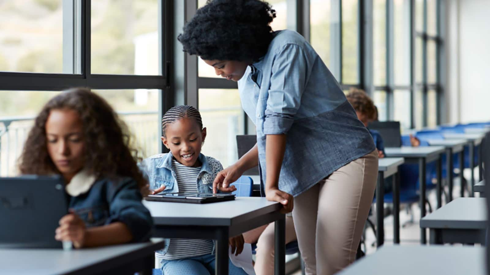 Teacher at her students desk helping