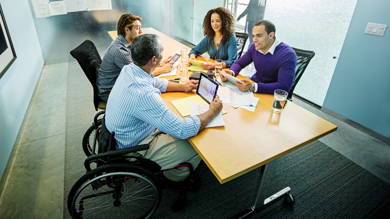 People in a boardroom sitting and speaking