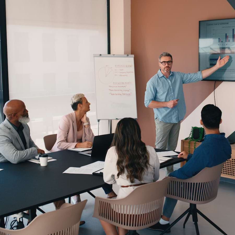 konferenču telpā pulcējušies speciālisti prezentē datus klientiem