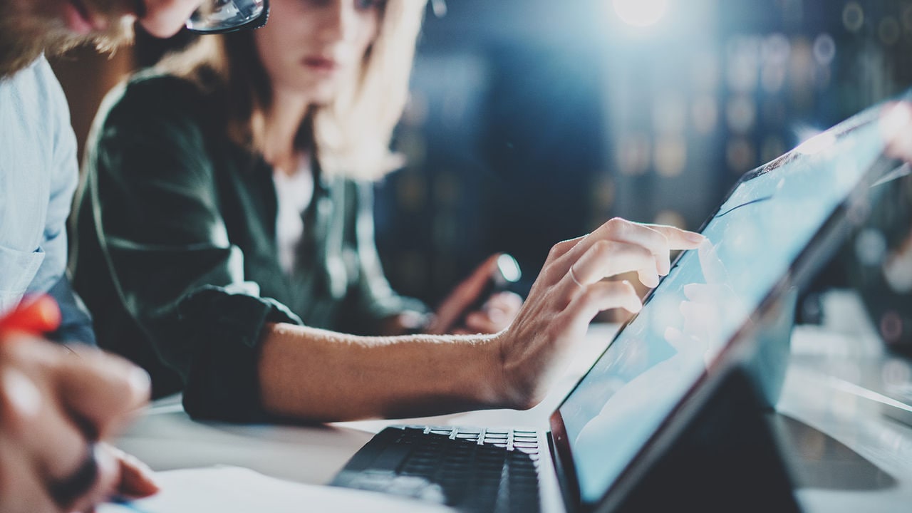 Team working on laptops at a modern conference room table