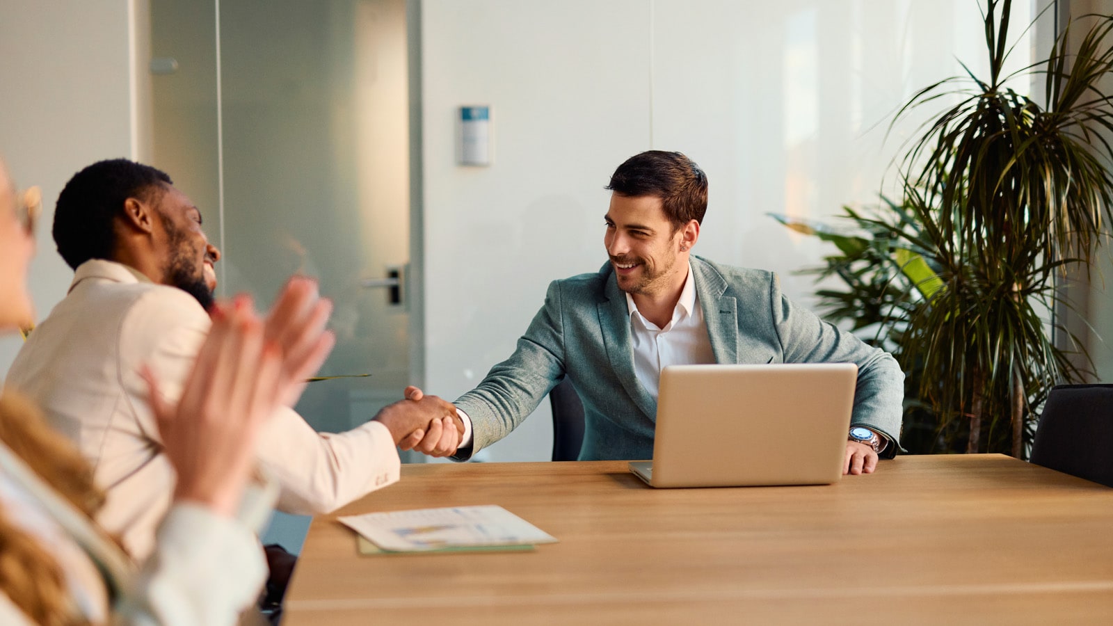 Business colleagues shaking hands in a meeting in a conference room
