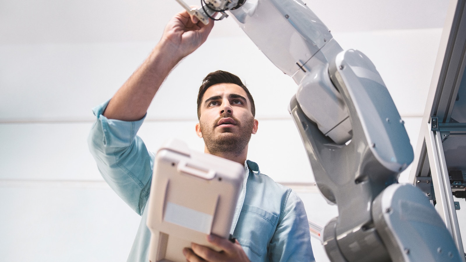 Engineer adjusting robotic arm