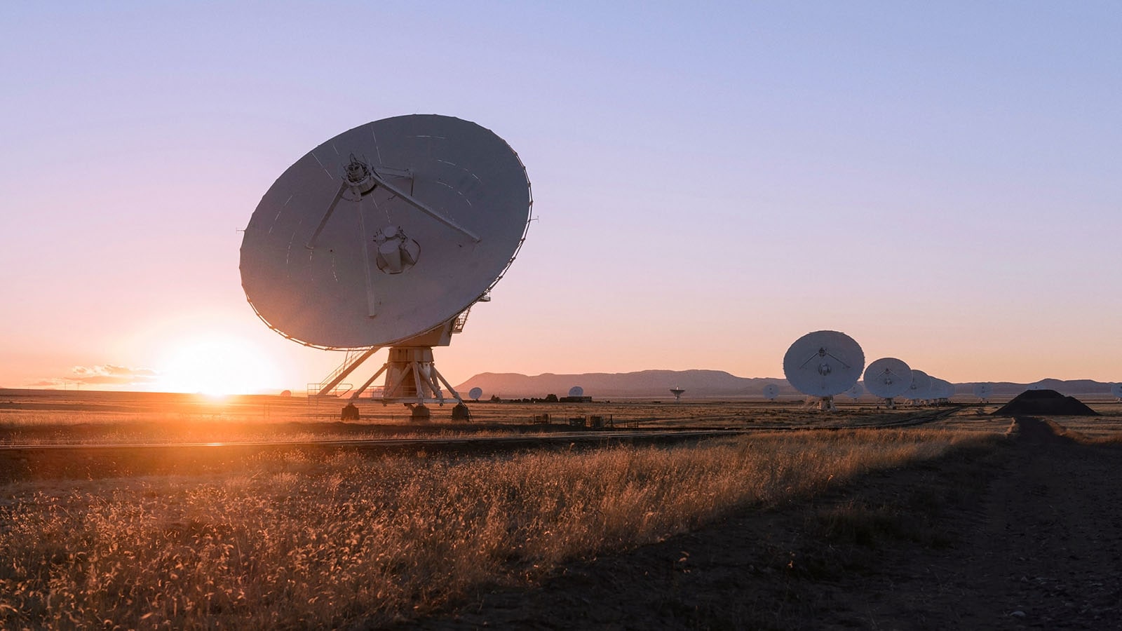 Large satellite dishes at sunset in desert