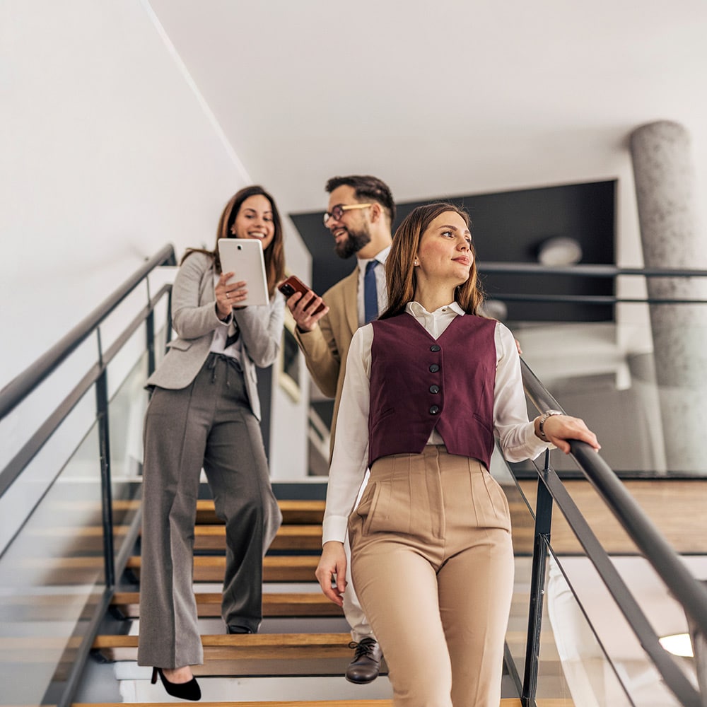 3 people walking down office stairs