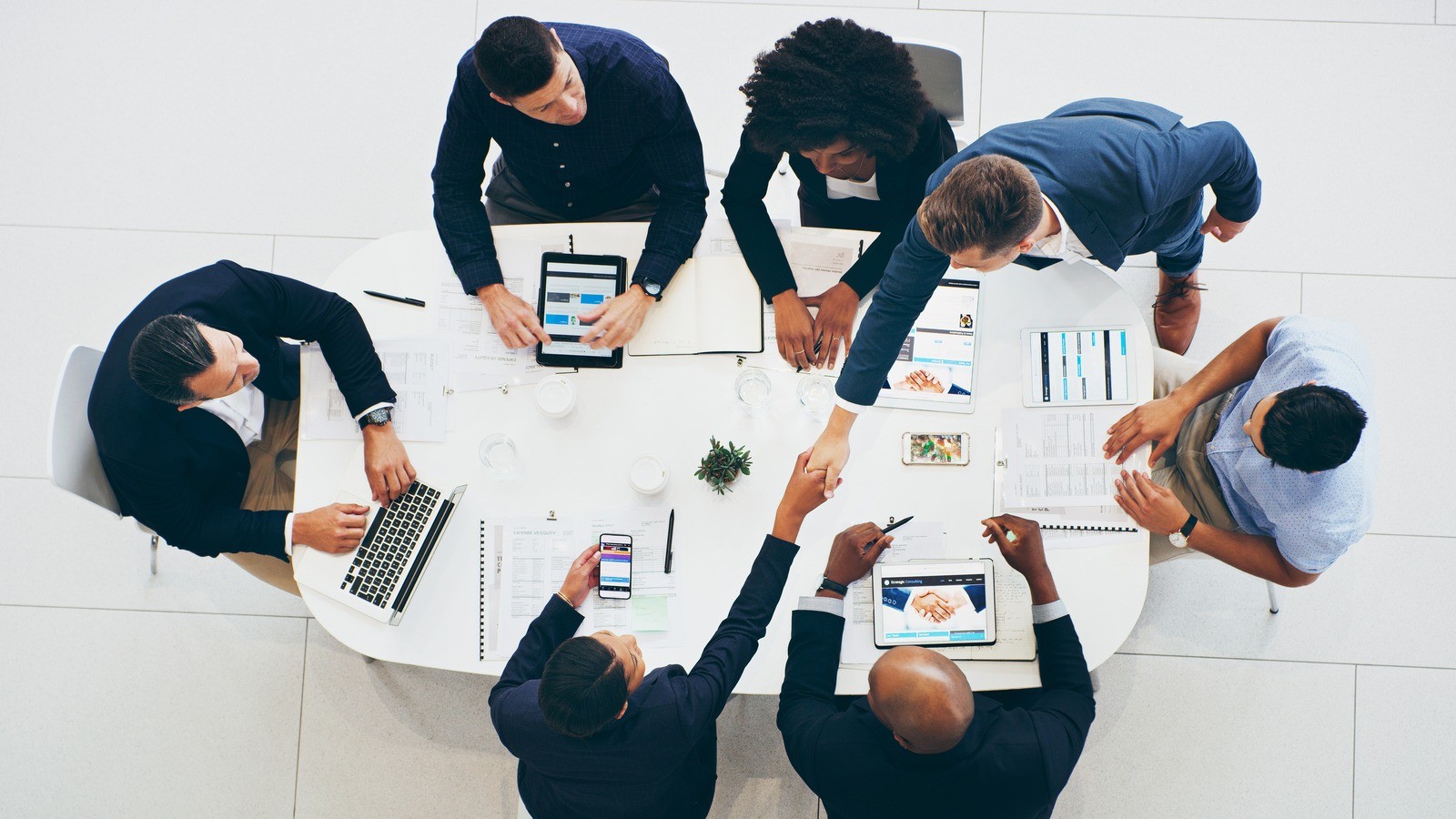 Businessman and businesswoman shaking hands during a meeting in a modern office
