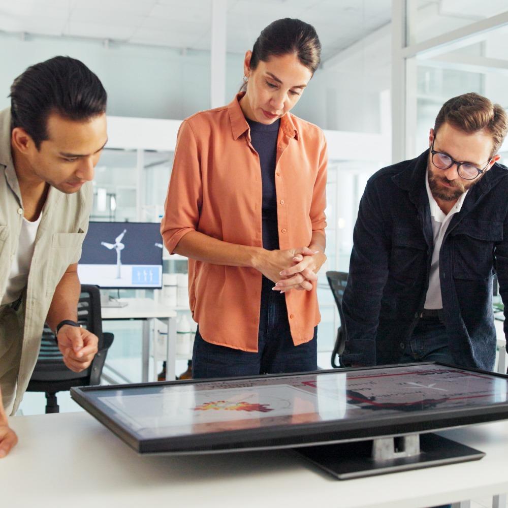 Three people looking at a laptop