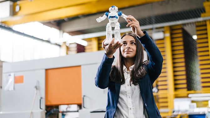 Schoolgirl holding a small robot