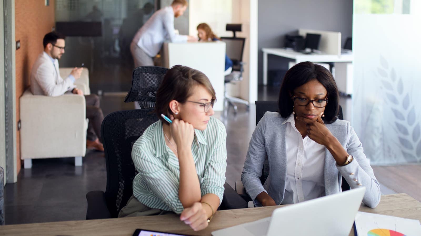 Businesswomen with laptop, digital tablet and financial charts