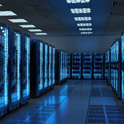 A dimly lit room of server cabinets glowing blue