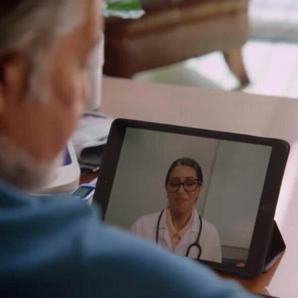 Close-up of a person using a tablet to connect to a telehealth provider