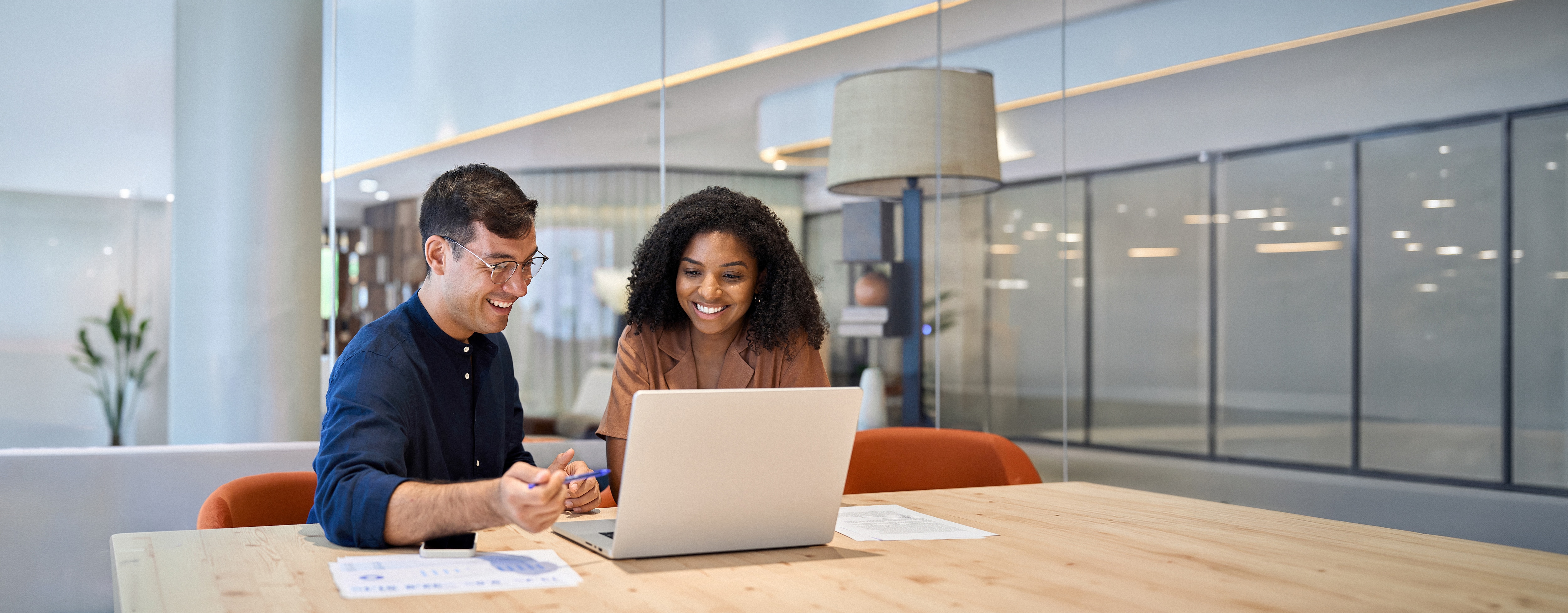 Two office workers using a laptop