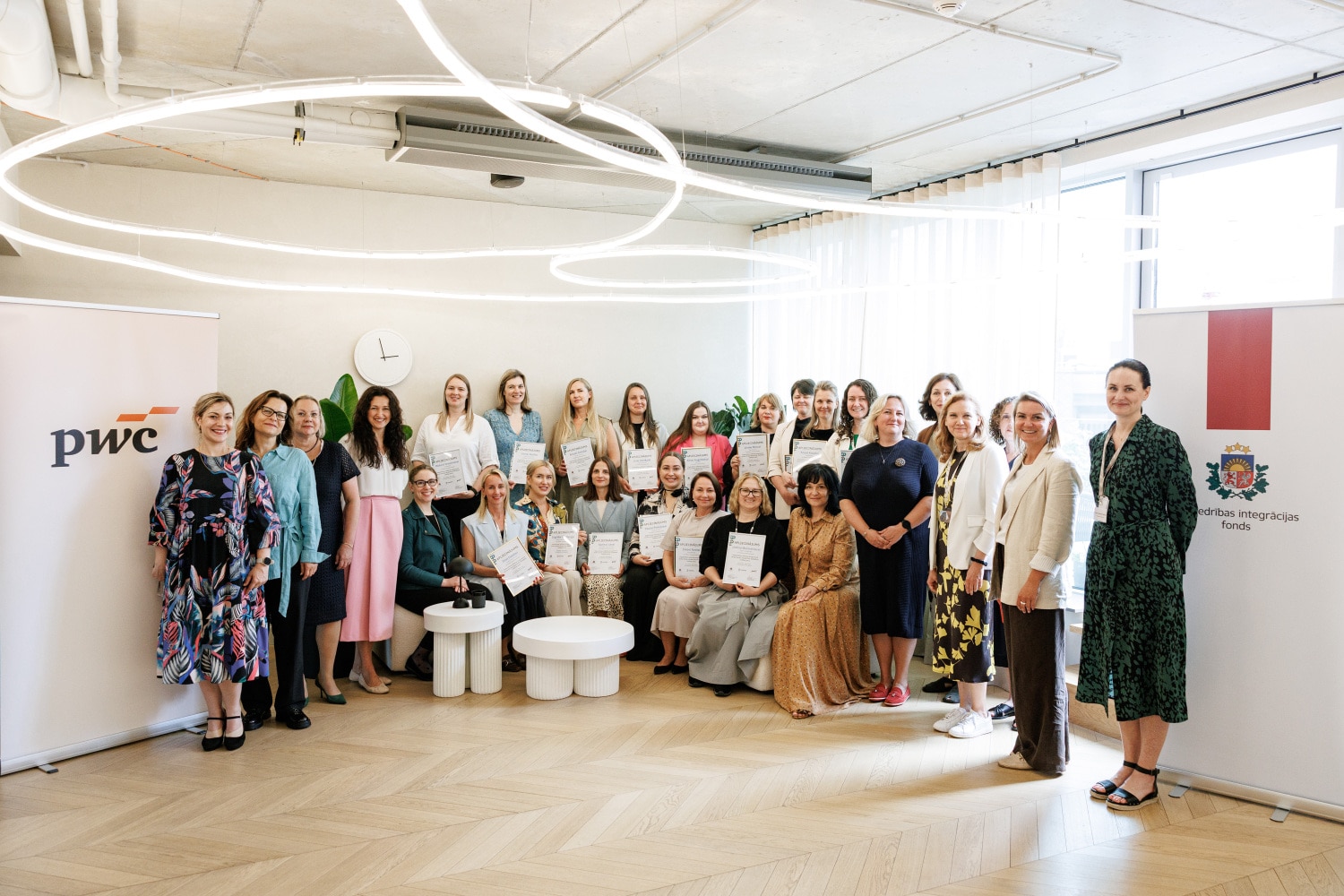 grupa smaidīgu cilvēku, kas saņēmuši apliecinājumu par mācību noklausīšanos