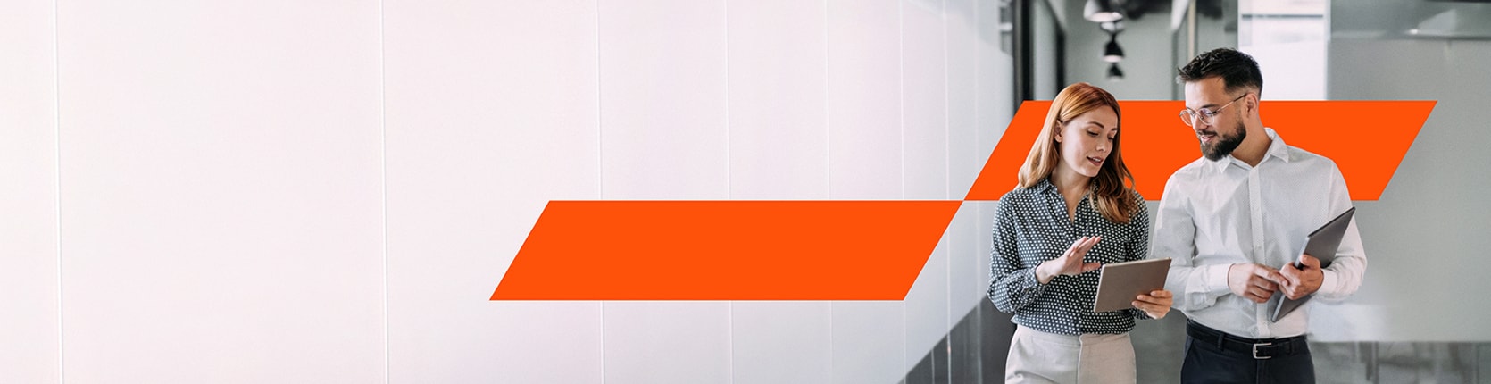 a woman showing something in a tablet to her male colleague