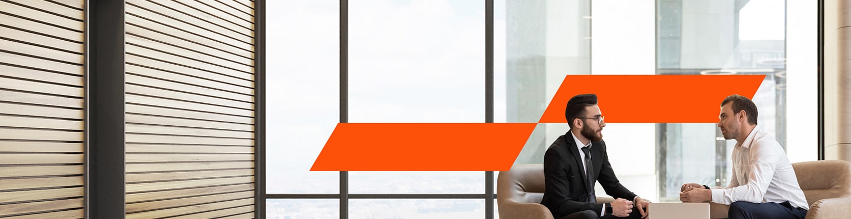 two man sitting around the table in an office and discussing business