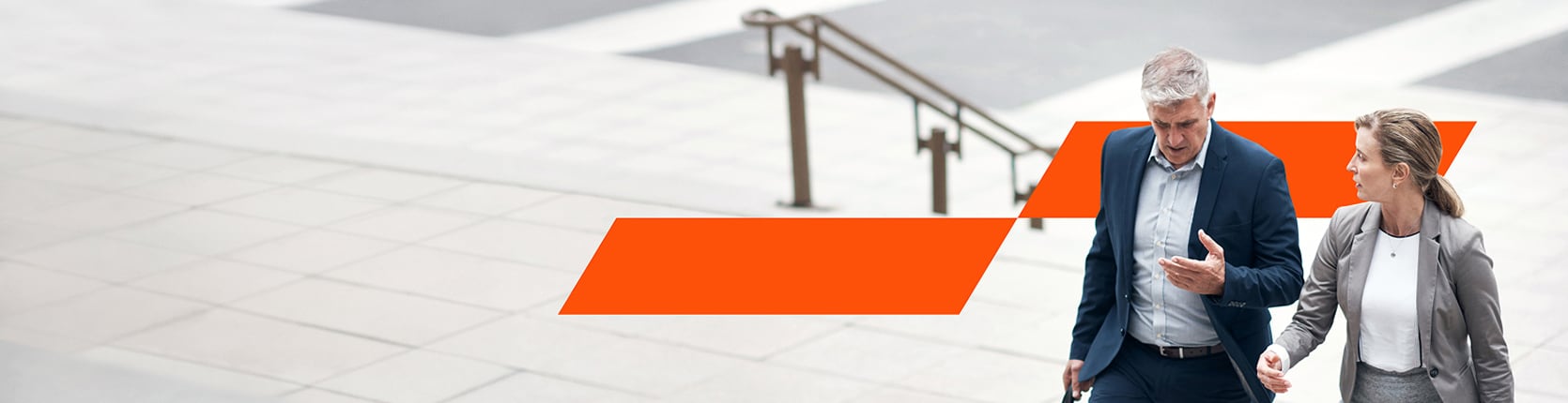 a man and a woman walking up the stairs and having a formal discussion