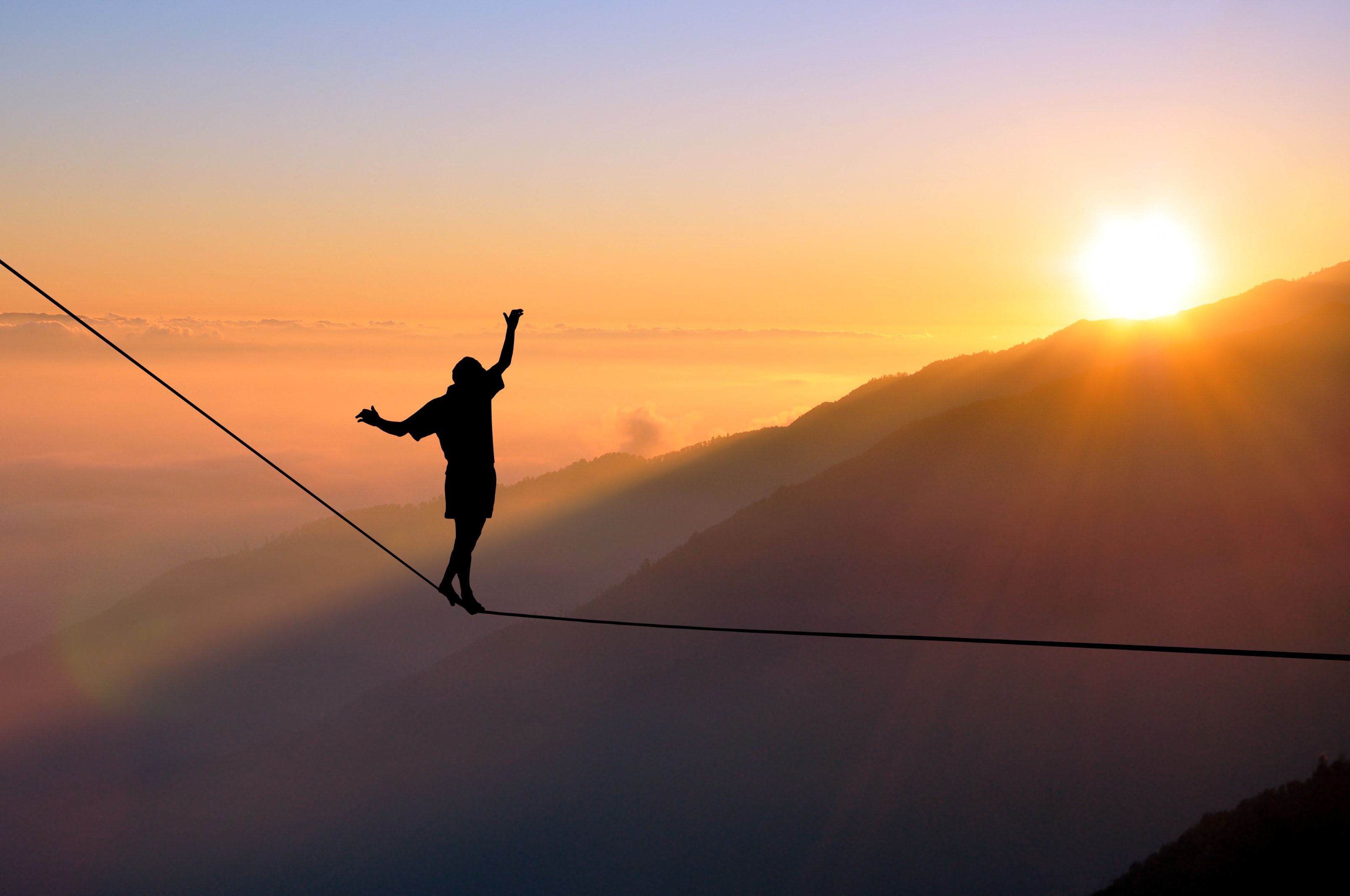 Silhouette of young man balancing