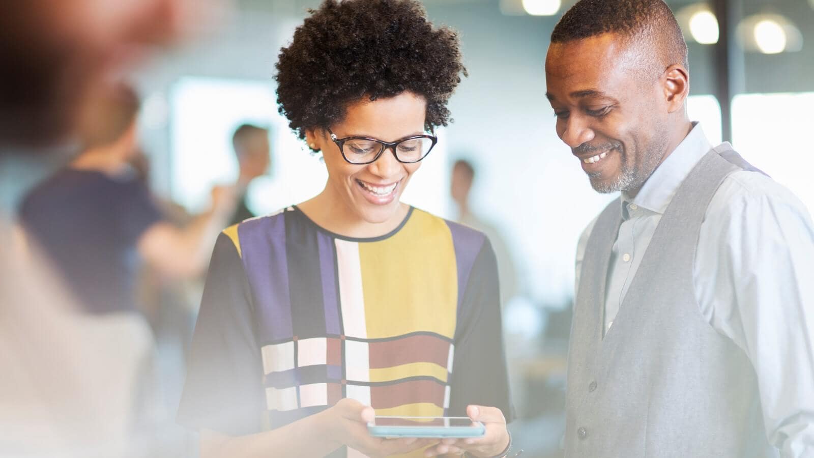 Two people reading about the Rwanda budget on a tablet.