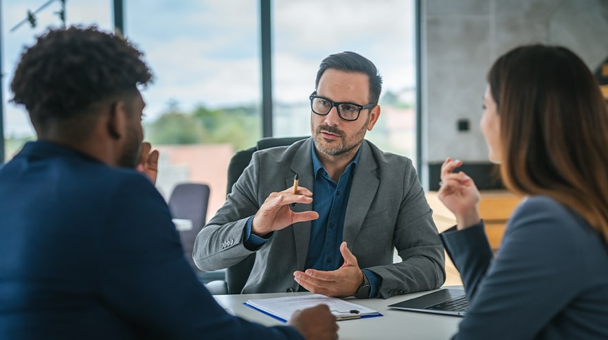 3 people talking at a table