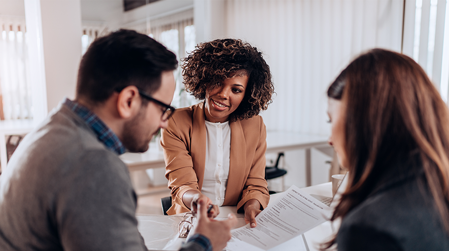 A person discussing paperwork with a couple